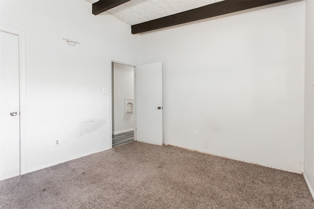 carpeted empty room featuring vaulted ceiling with beams