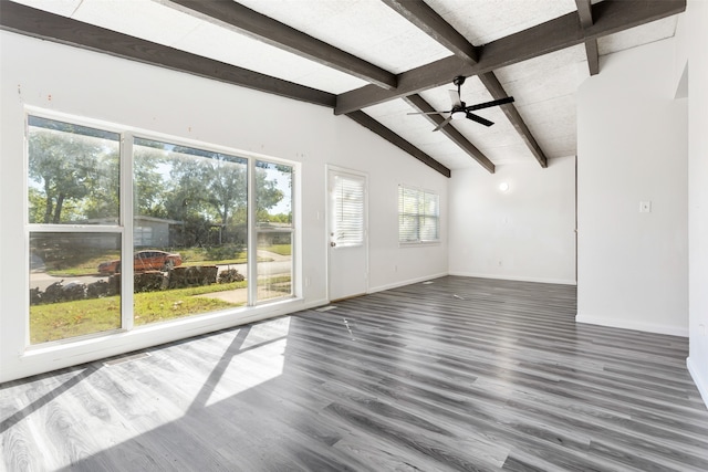 unfurnished living room featuring lofted ceiling with beams, a wealth of natural light, ceiling fan, and dark hardwood / wood-style flooring