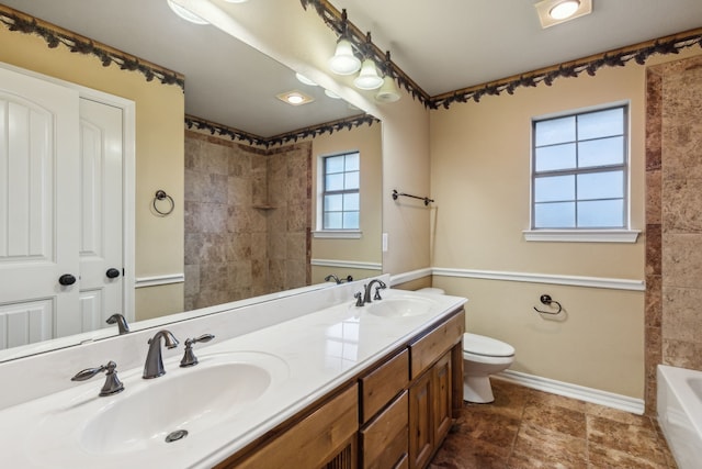 bathroom featuring toilet, vanity, and a healthy amount of sunlight