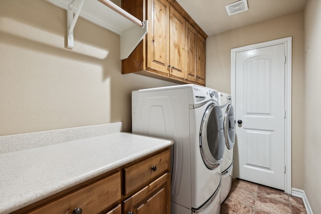 laundry room featuring cabinets and washer and dryer