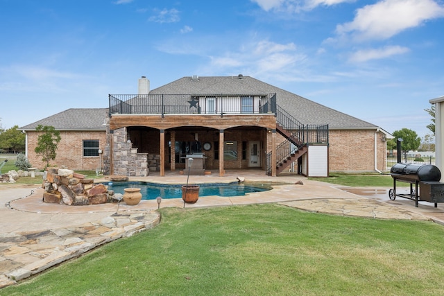 rear view of house featuring a yard, a patio, and a pool side deck