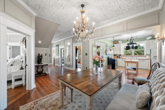 living room featuring hardwood / wood-style floors, ornamental molding, lofted ceiling, and sink