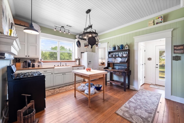 kitchen with hardwood / wood-style flooring, white cabinetry, white appliances, and sink