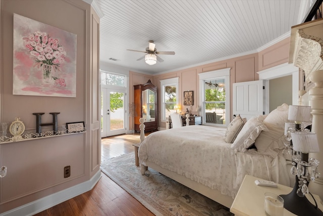 bedroom with access to outside, multiple windows, ceiling fan, and hardwood / wood-style floors