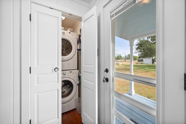 washroom featuring dark hardwood / wood-style floors and stacked washer / dryer