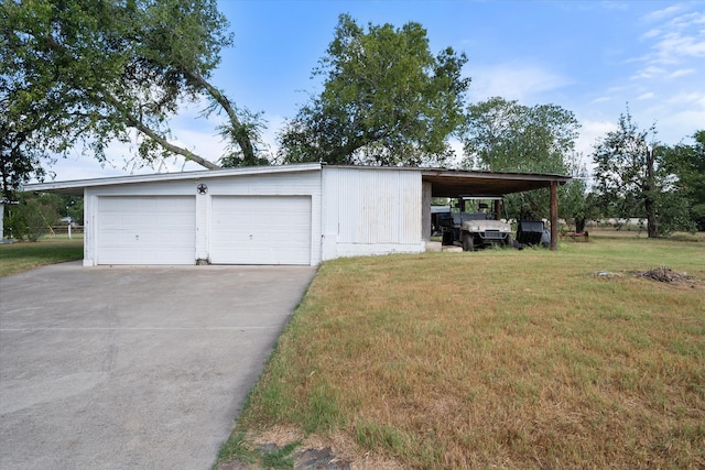 garage featuring a yard and a carport