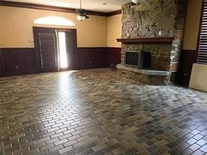 unfurnished living room with crown molding and a fireplace