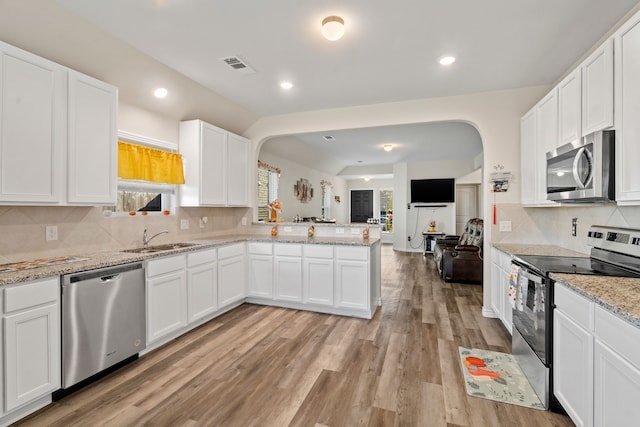 kitchen with white cabinetry, stainless steel appliances, light hardwood / wood-style floors, and sink