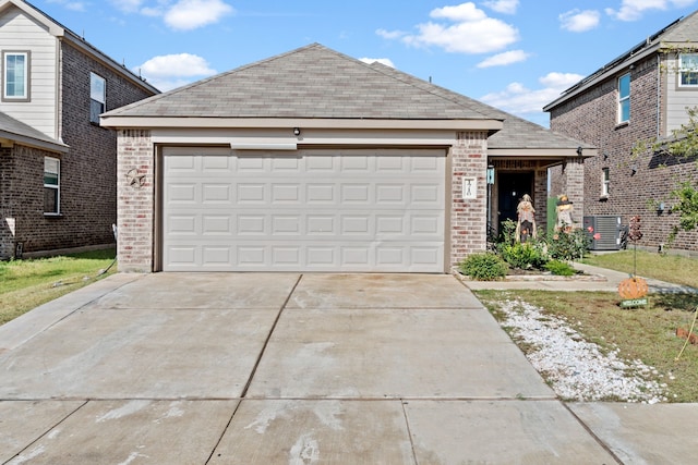 view of front of home with a garage and cooling unit