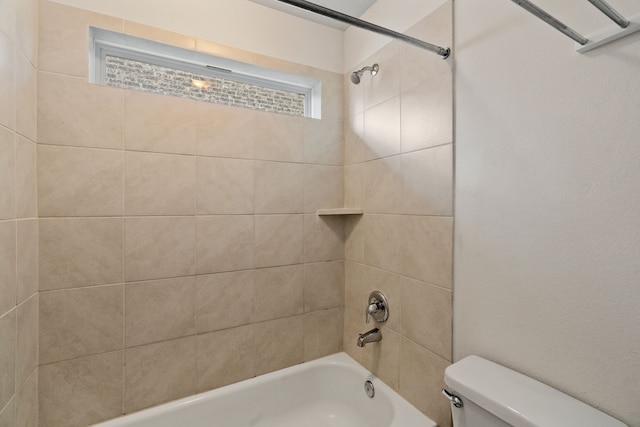 bathroom featuring toilet and tiled shower / bath