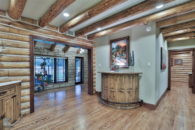 bar featuring rustic walls, light hardwood / wood-style flooring, and beamed ceiling