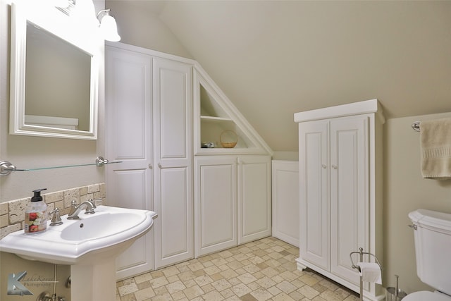 bathroom with toilet and lofted ceiling