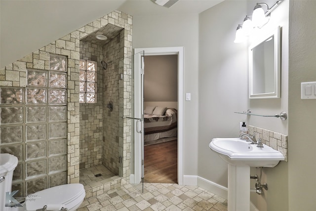 bathroom featuring hardwood / wood-style flooring, toilet, and a tile shower