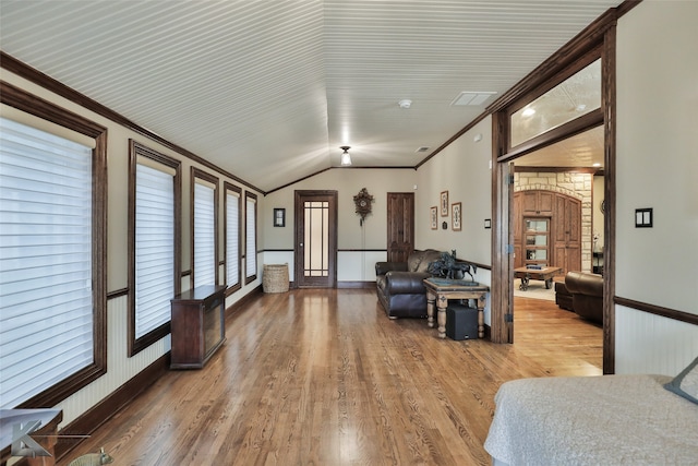 living room with hardwood / wood-style flooring, crown molding, and vaulted ceiling