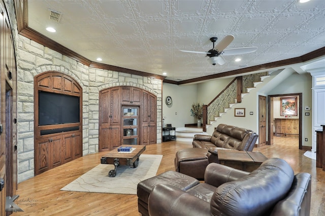 living room featuring ceiling fan, decorative columns, light hardwood / wood-style floors, and crown molding