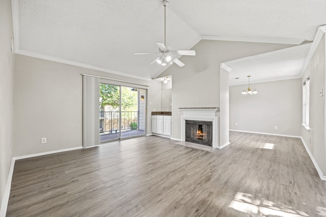 unfurnished living room featuring lofted ceiling, crown molding, hardwood / wood-style flooring, a textured ceiling, and ceiling fan with notable chandelier