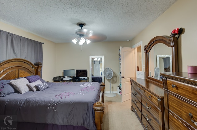 carpeted bedroom featuring a textured ceiling, ceiling fan, and ensuite bath