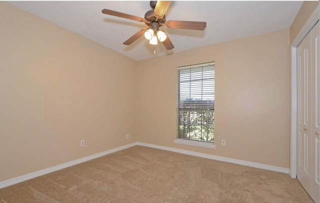 carpeted spare room with ceiling fan