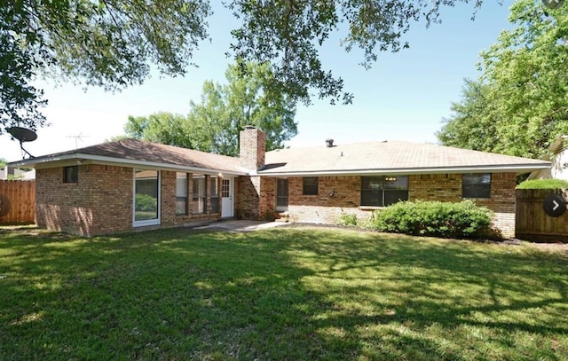 rear view of property with a lawn