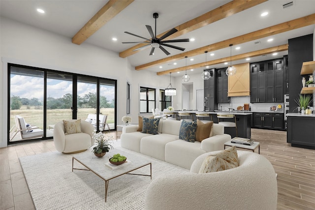 living room featuring beamed ceiling, ceiling fan, and light hardwood / wood-style flooring