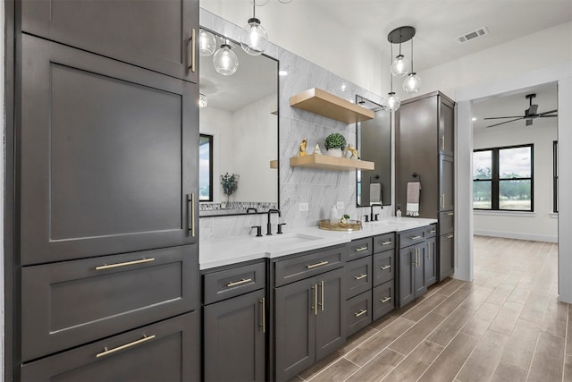 bathroom featuring hardwood / wood-style floors, vanity, ceiling fan, and backsplash