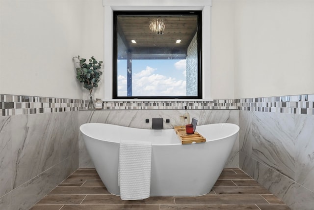 bathroom featuring tile walls and a tub