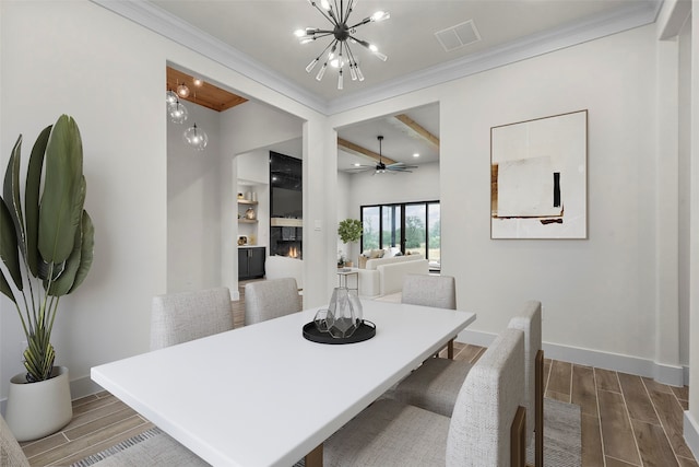 dining space with ornamental molding, hardwood / wood-style floors, and ceiling fan with notable chandelier