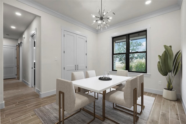 dining room featuring an inviting chandelier, a barn door, light hardwood / wood-style floors, and crown molding