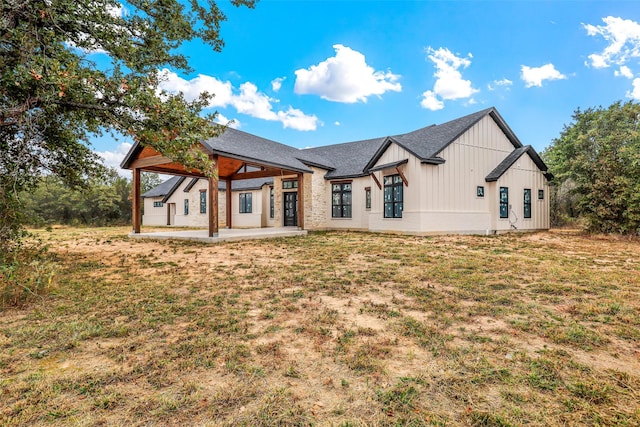 rear view of house featuring a yard and a patio area