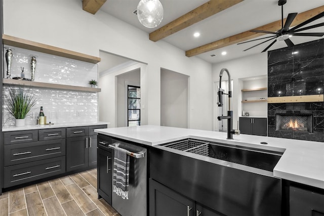 kitchen featuring light hardwood / wood-style floors, a premium fireplace, sink, tasteful backsplash, and beamed ceiling