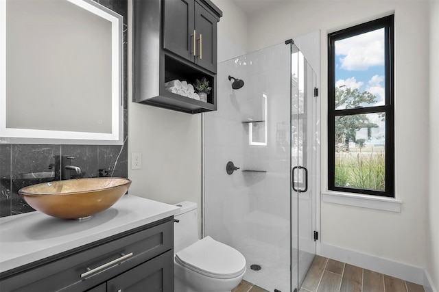 bathroom featuring a wealth of natural light, a shower with door, vanity, and hardwood / wood-style flooring