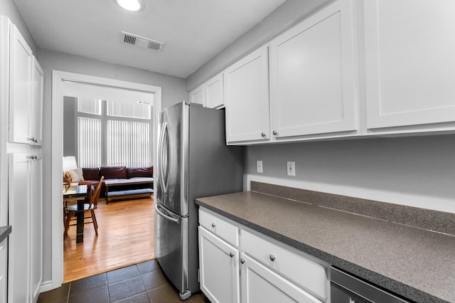 kitchen featuring white cabinets, dark hardwood / wood-style floors, and stainless steel refrigerator