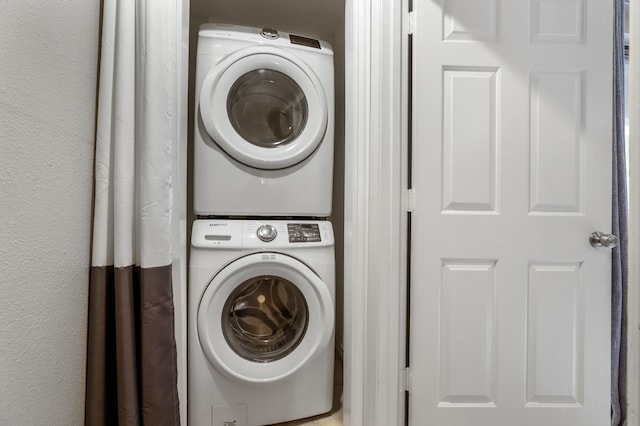 laundry room featuring stacked washer / drying machine