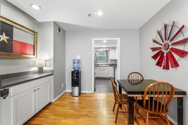 dining space featuring sink and light hardwood / wood-style flooring