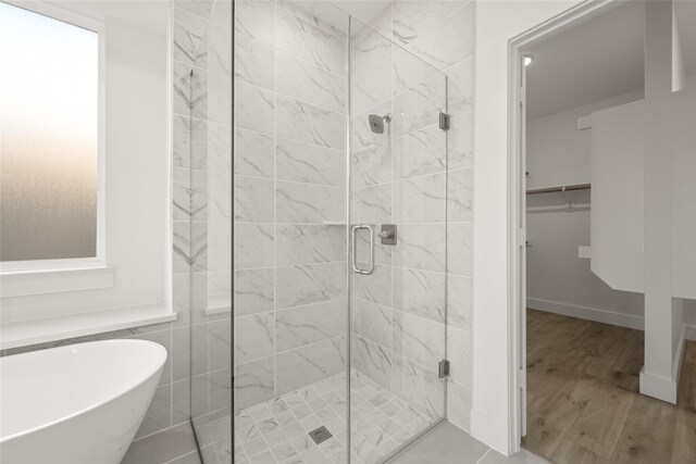 bathroom featuring plus walk in shower and wood-type flooring