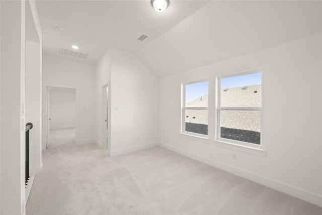 bonus room with light colored carpet and vaulted ceiling