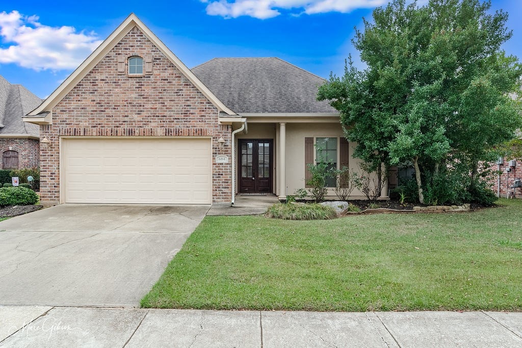 view of front of home with a front yard and french doors