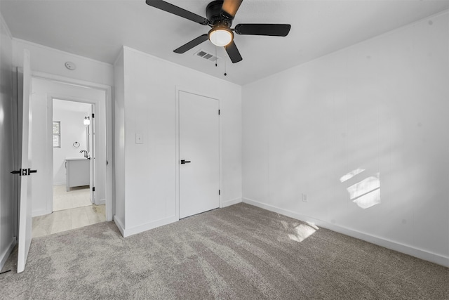 unfurnished bedroom with a closet, light colored carpet, and ceiling fan