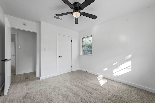 unfurnished bedroom featuring light carpet, ceiling fan, and a closet