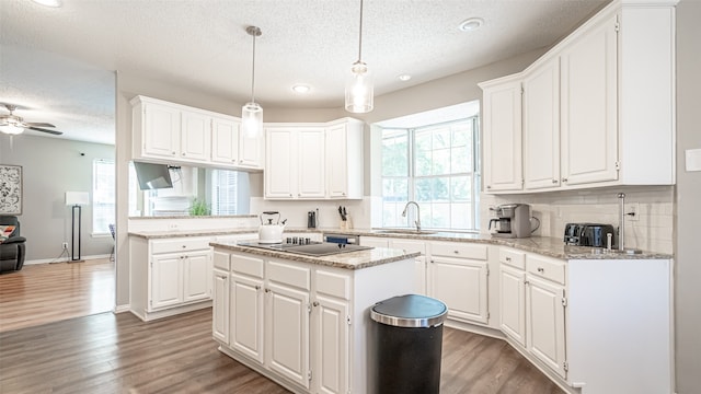 kitchen with white cabinetry, pendant lighting, and a center island