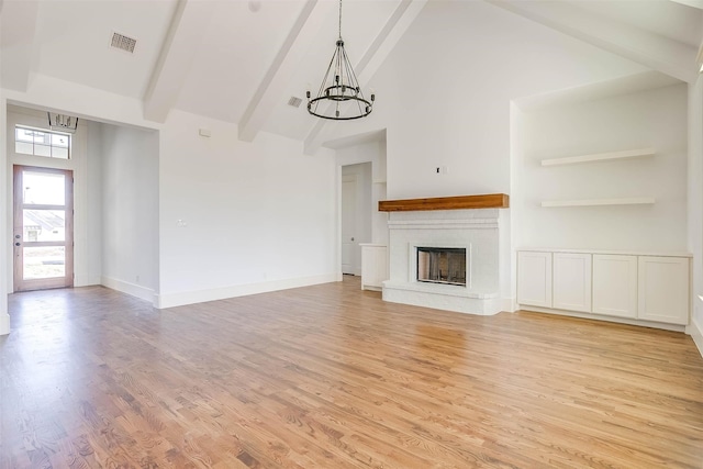 unfurnished living room featuring high vaulted ceiling, beamed ceiling, light wood-type flooring, and an inviting chandelier