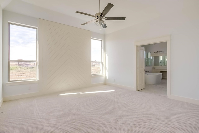 unfurnished bedroom featuring multiple windows, light colored carpet, and ceiling fan