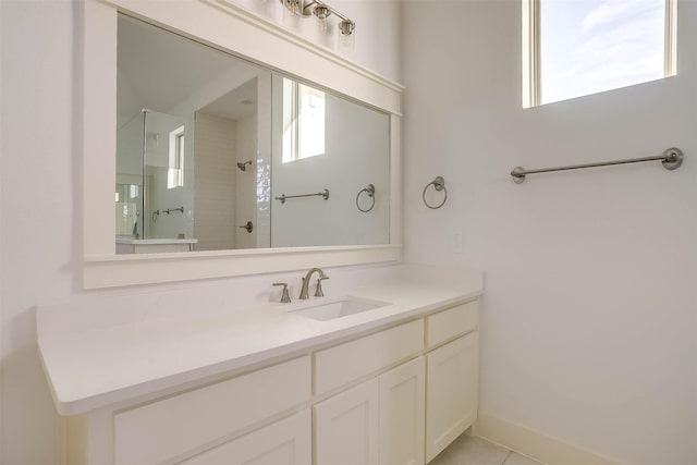 bathroom featuring vanity, tile patterned floors, and a tile shower