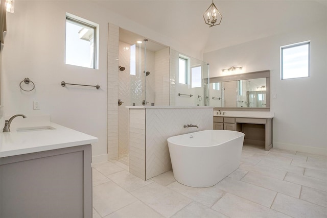 full bathroom with a walk in shower, a freestanding tub, vanity, and baseboards