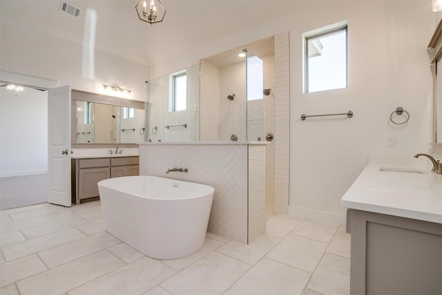 full bathroom featuring a freestanding bath, visible vents, walk in shower, and a sink