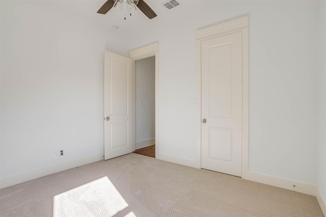 unfurnished bedroom featuring ceiling fan and light carpet