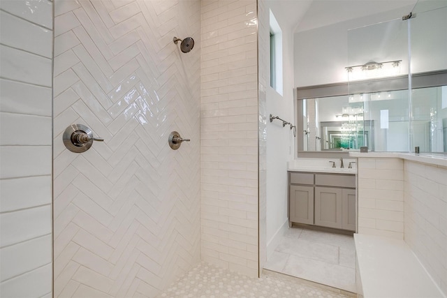 bathroom with tiled shower and vanity