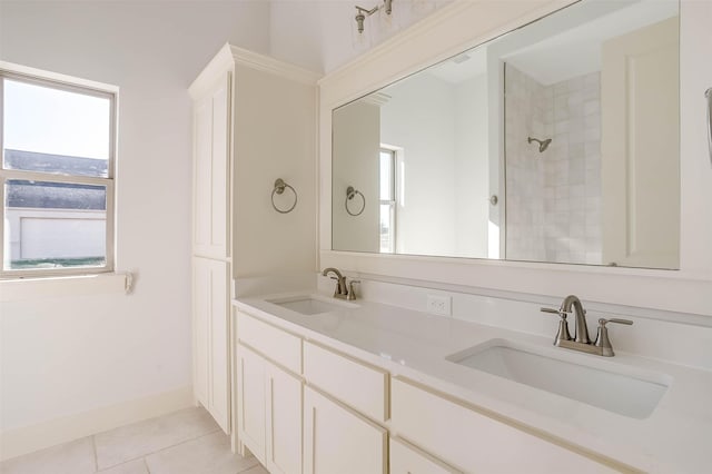 bathroom featuring tile patterned flooring, vanity, and a tile shower