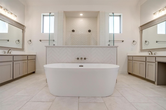 bathroom with a wealth of natural light, a freestanding tub, and a sink