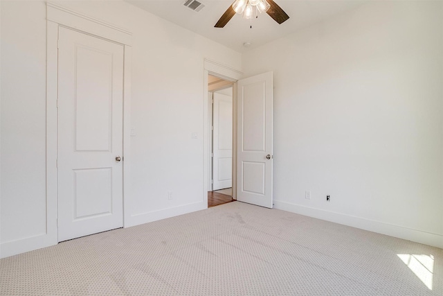 unfurnished bedroom featuring ceiling fan, carpet flooring, visible vents, and baseboards